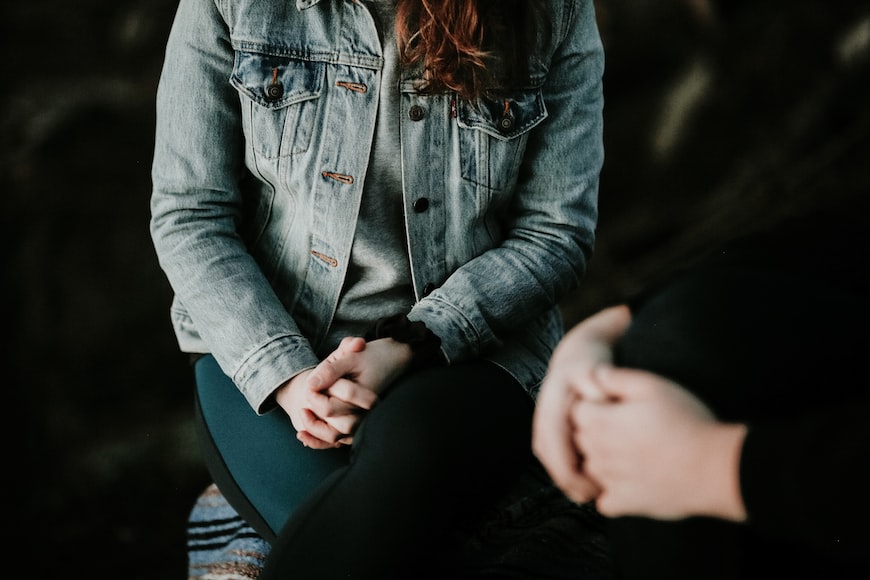 two people sat together praying