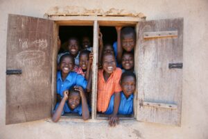 A group of young children in Uganda standing in a window