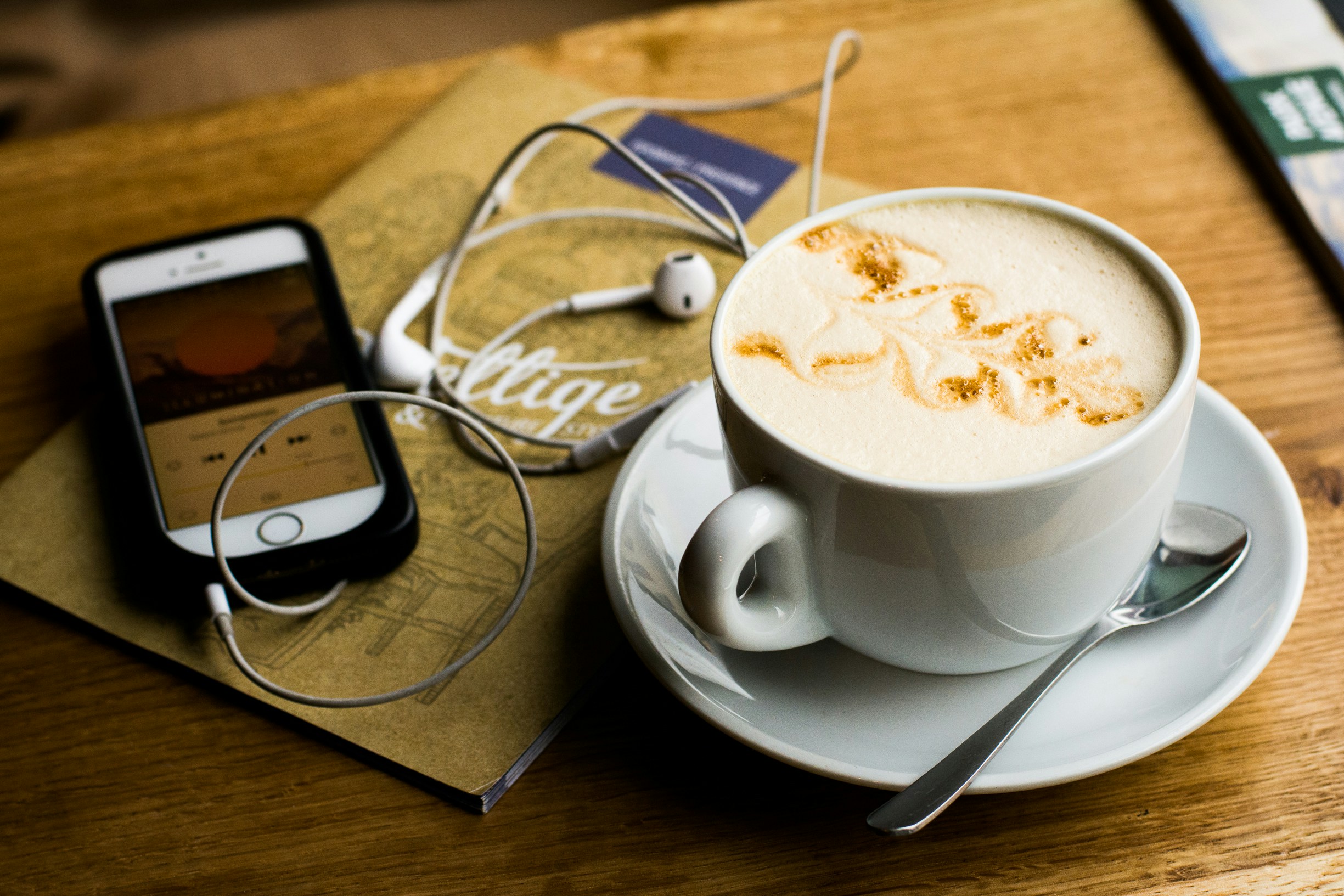 mobile with headphones book and coffee
