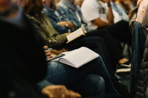 people sitting in a meeting with notebooks open