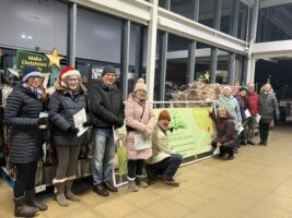 a group of POBD people singing outside Sainsbury's shop