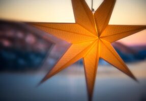 photo of a yellow paper star hanging in a window