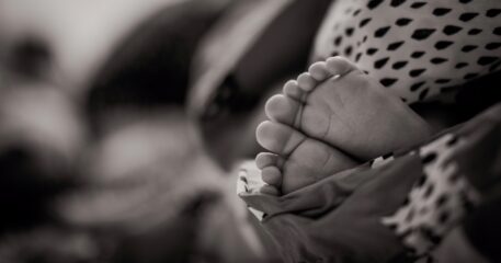 black and white image of baby feet wrapped in blanket