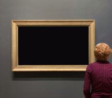 a woman looking at a painting of a black canvas